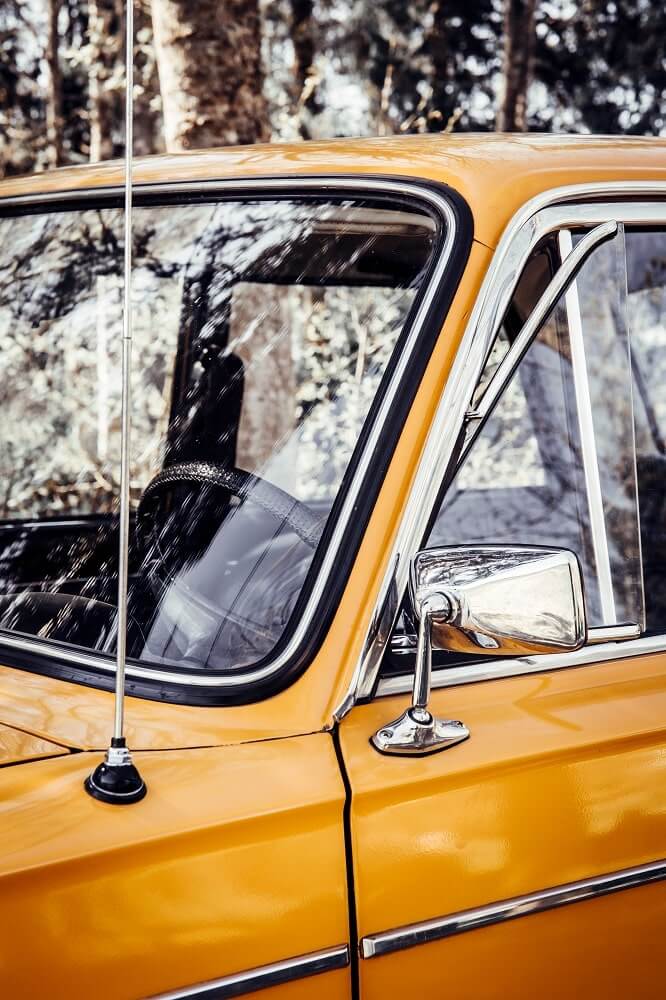 A vintage yellow truck with a locking window gasket